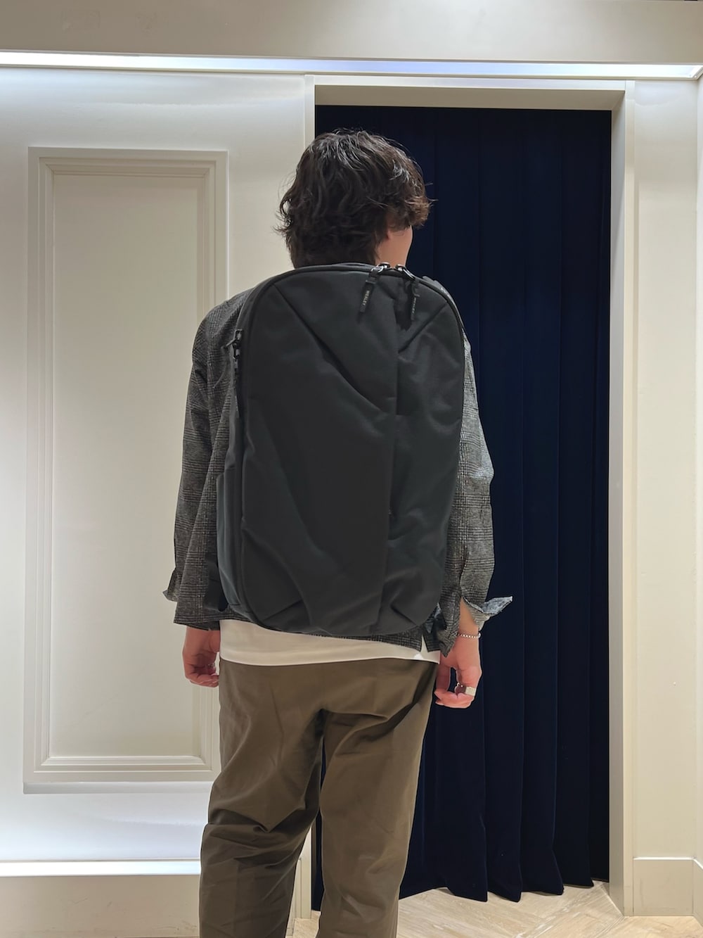 グレー系のブルゾン、ホワイト系のTシャツ/カットソー、ブラック系のバックパック/リュックを着用したメンズの春コーディネートの9枚目の写真