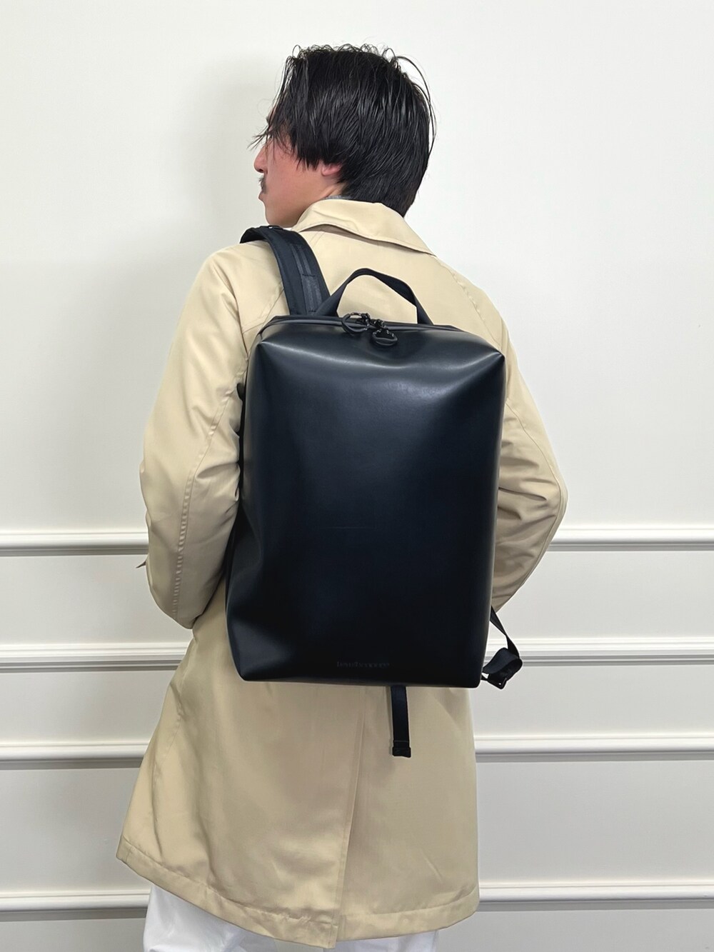 ベージュ系のステンカラーコート、ブラック系のシャツ/ブラウス、ホワイト系のデニムパンツを着用したメンズの冬コーディネートの9枚目の写真