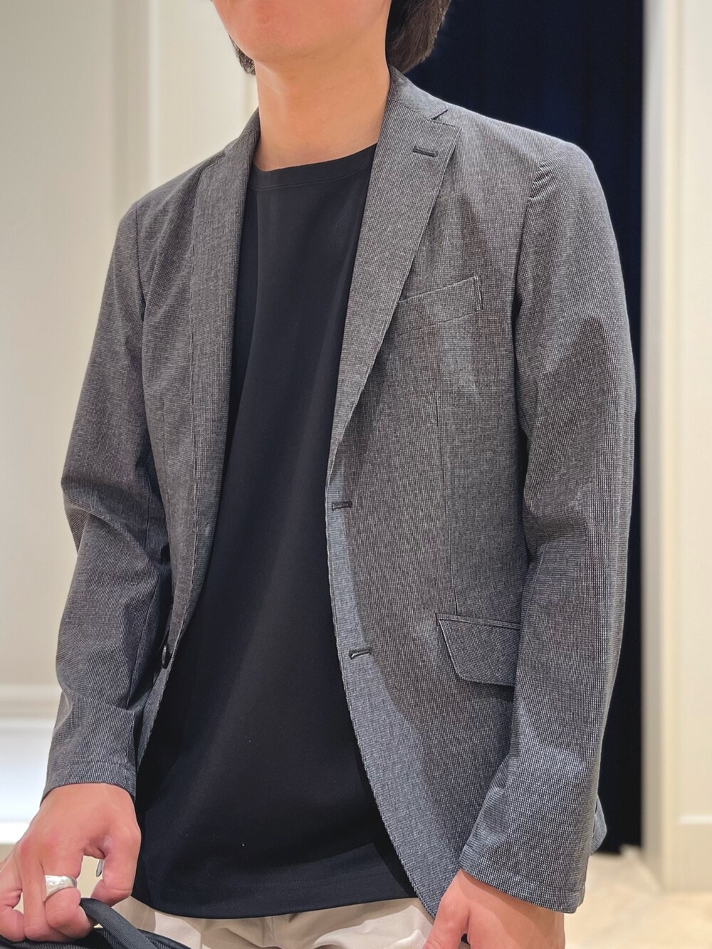 グレー系のテーラードジャケット、ブラック系のTシャツ/カットソー、ホワイト系のチノパンツを着用したメンズの春コーディネートの7枚目の写真