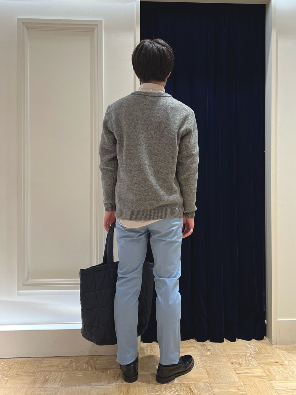 グレー系のニット/セーター、ベージュ系のシャツ/ブラウス、ブルー系のチノパンツを着用したメンズの冬コーディネートの5枚目の写真
