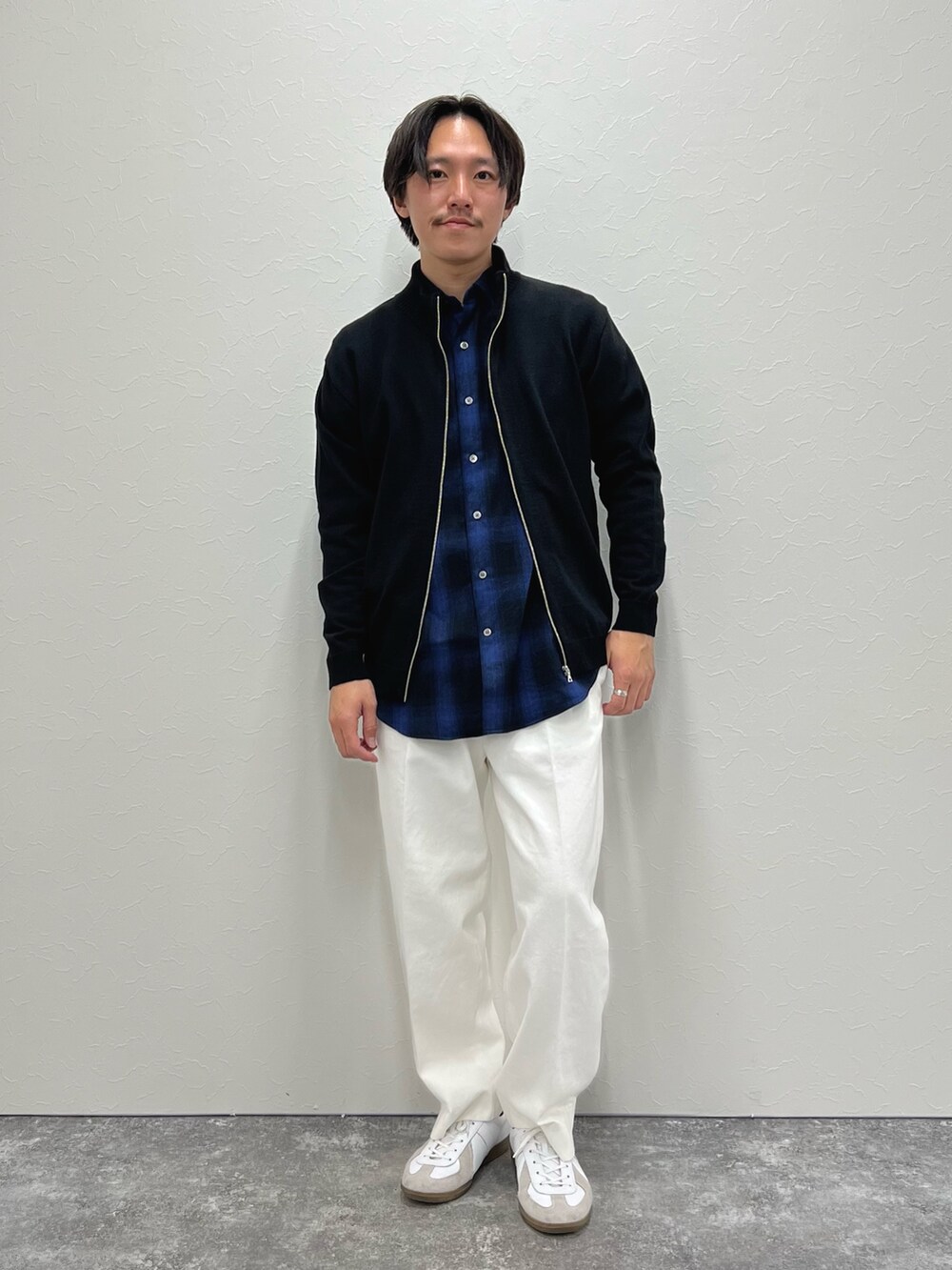ブラック系のカーディガン/ボレロ、ブルー系のシャツ/ブラウス、ホワイト系のデニムパンツを着用したメンズの冬コーディネートの2枚目の写真