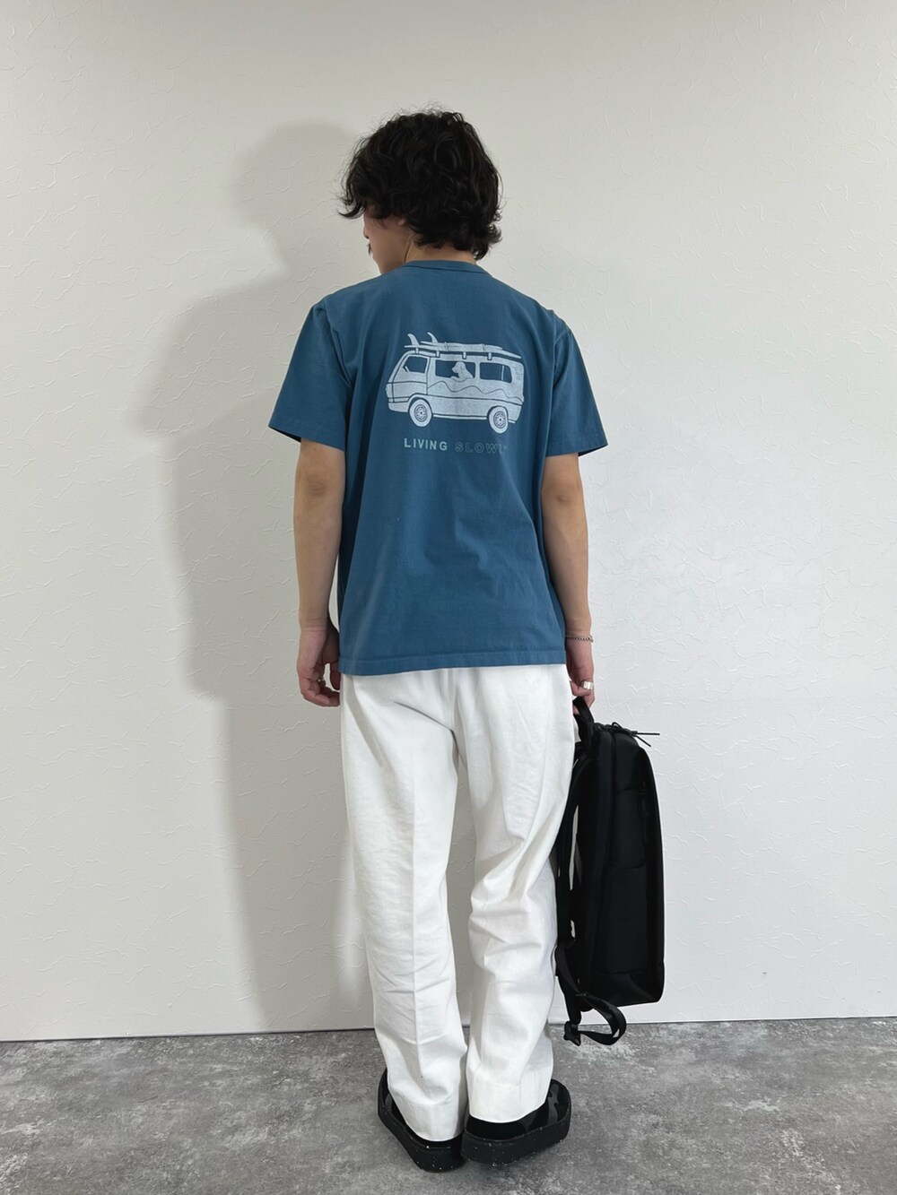 ブルー系のTシャツ/カットソー、ブラック系のショルダーバッグ、ホワイト系のデニムパンツを着用したメンズの春コーディネートの3枚目の写真