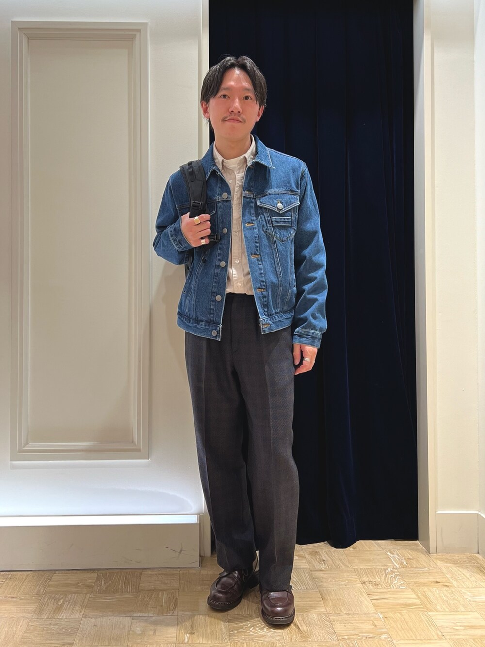 ブルー系のデニムジャケット、ベージュ系のシャツ/ブラウス、ブラック系のバックパック/リュックを着用したメンズの冬コーディネートの3枚目の写真