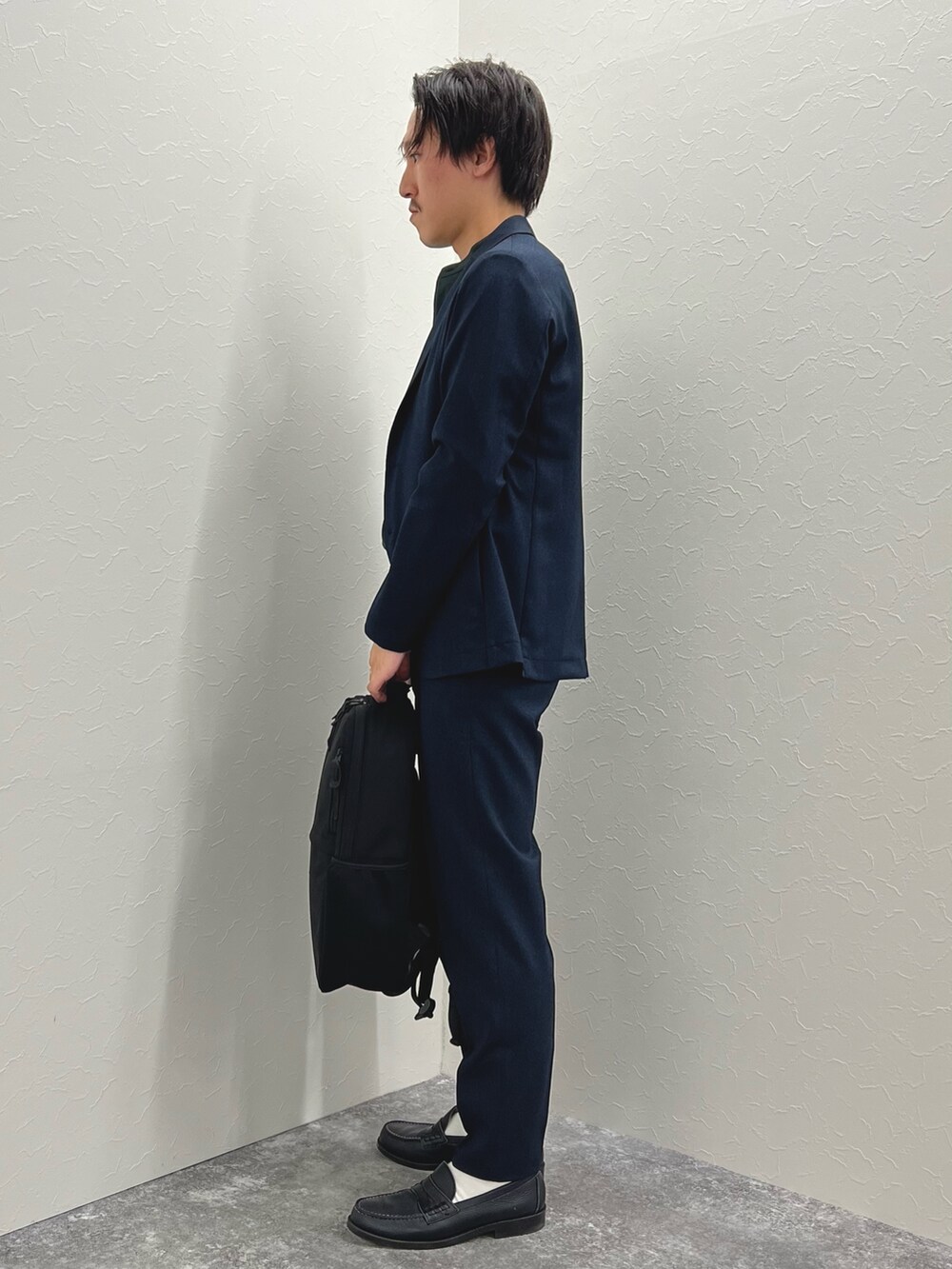 ブルー系のテーラードジャケット、ブルー系のその他パンツ、ブラック系のバックパック/リュックを着用したメンズの秋コーディネートの3枚目の写真