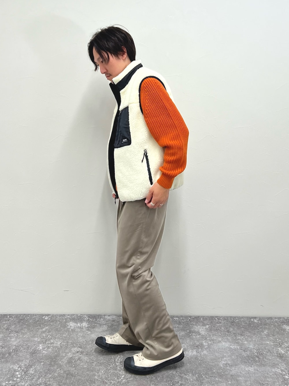 ホワイト系のダウンベスト、ベージュ系のその他パンツを着用したメンズの秋コーディネートの8枚目の写真