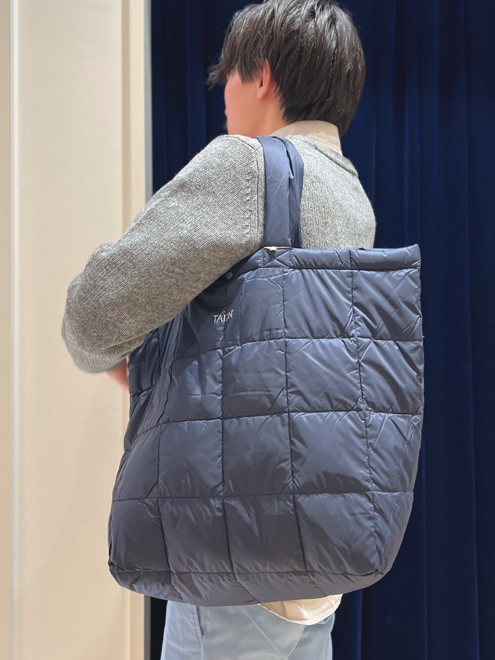 グレー系のニット/セーター、ベージュ系のシャツ/ブラウス、ブルー系のチノパンツを着用したメンズの冬コーディネートの7枚目の写真