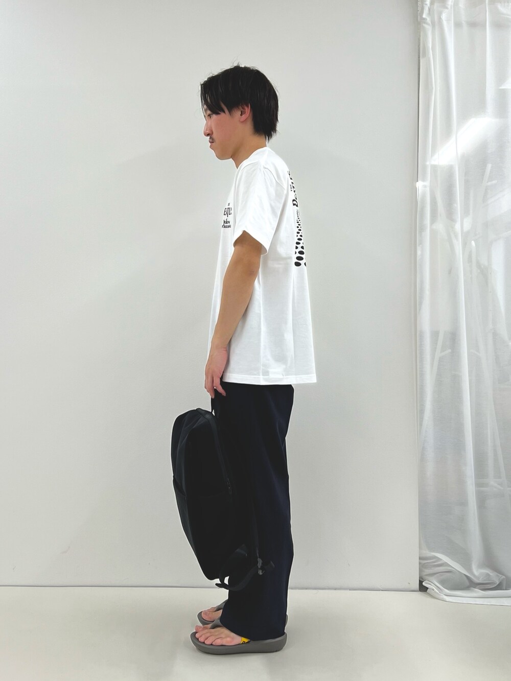ホワイト系のTシャツ/カットソー、ブラック系のその他パンツ、ブラック系のバックパック/リュックを着用したメンズの春コーディネートの4枚目の写真