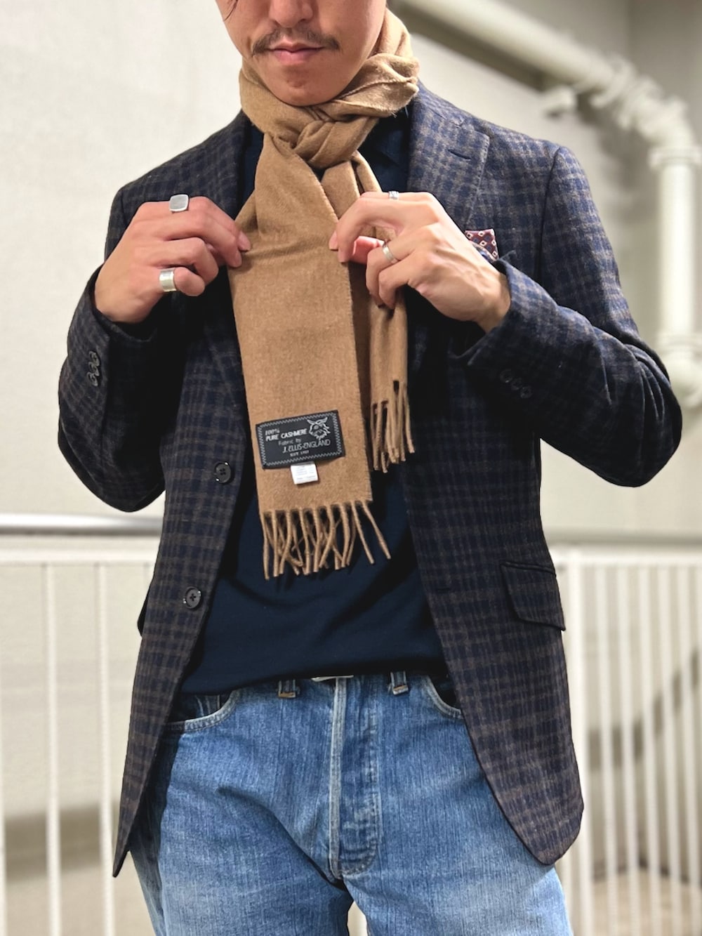 ブルー系のテーラードジャケット、ブラウン系のローファー、ブルー系のデニムパンツを着用したメンズの冬コーディネートの4枚目の写真