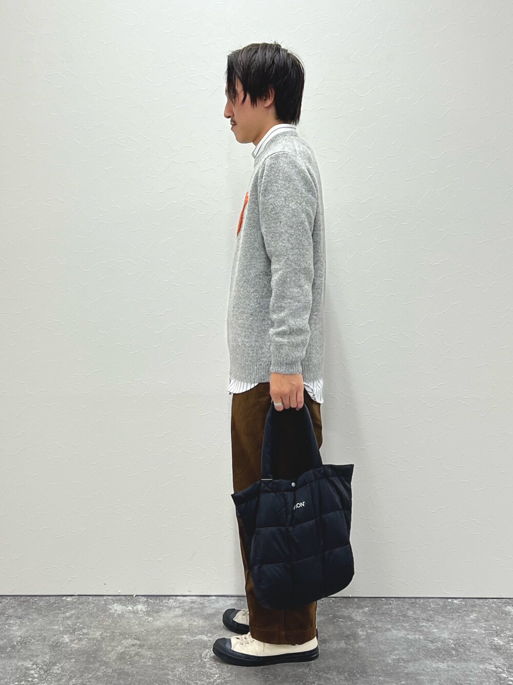 ホワイト系のシャツ/ブラウス、グレー系のニット/セーター、ブラック系のトートバッグを着用したメンズの秋コーディネートの4枚目の写真