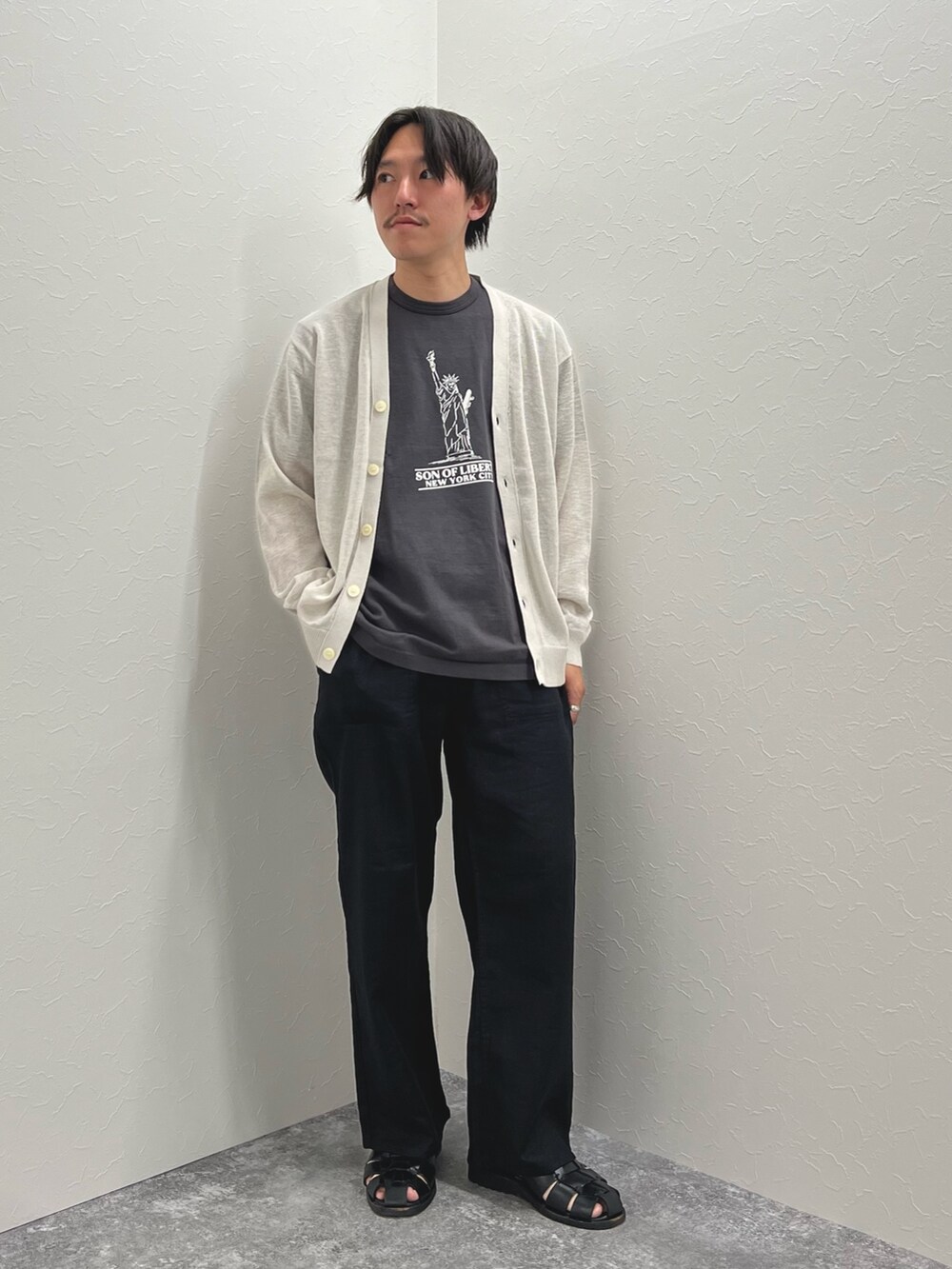 ベージュ系のカーディガン/ボレロ、グレー系のTシャツ/カットソー、ブラック系のサンダルを着用したメンズの春コーディネートの2枚目の写真