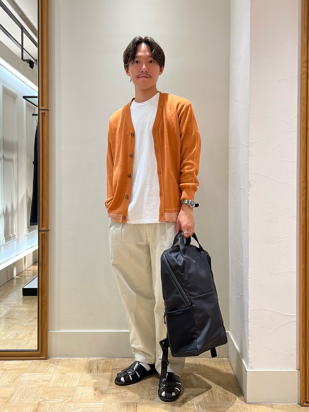 イエロー系のカーディガン/ボレロ、ブラック系のバックパック/リュックを着用したメンズの秋コーディネートの2枚目の写真