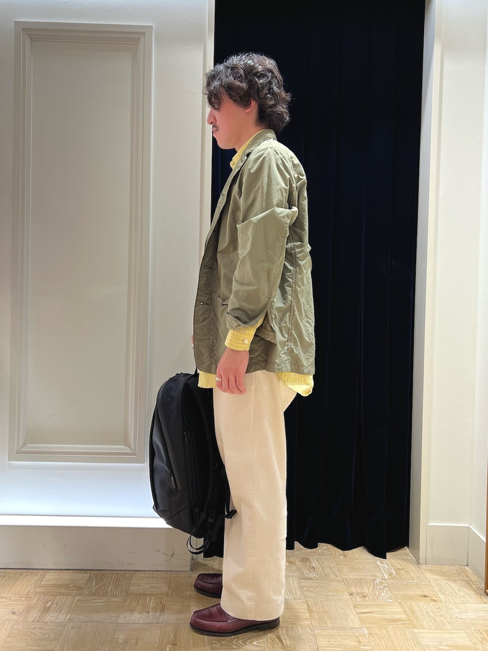 グリーン系のミリタリージャケット、レッド系のローファー、ホワイト系のデニムパンツを着用したメンズの春コーディネートの4枚目の写真