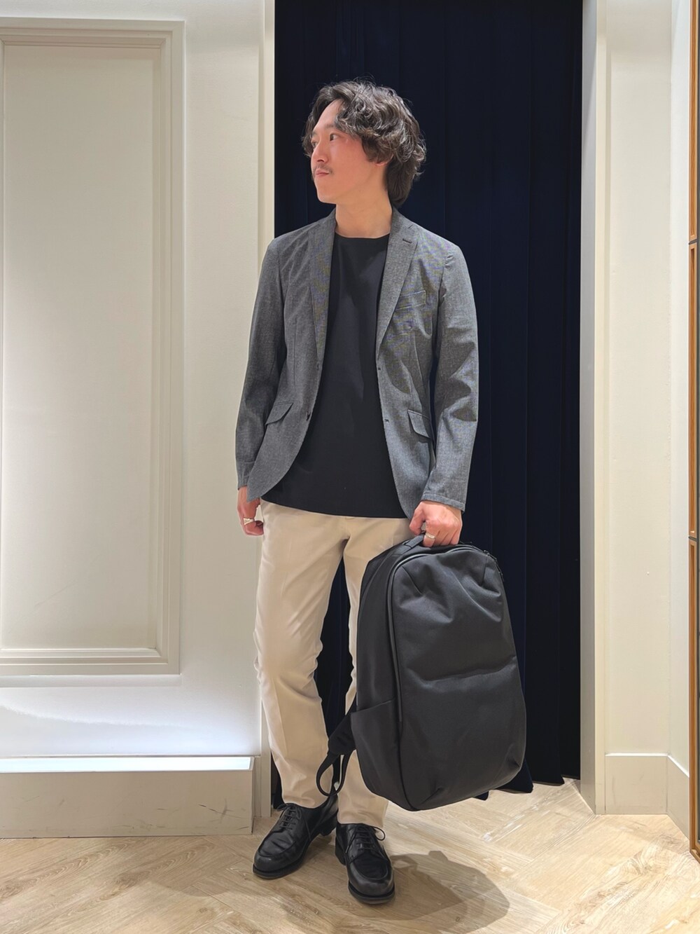 グレー系のテーラードジャケット、ブラック系のTシャツ/カットソー、ホワイト系のチノパンツを着用したメンズの春コーディネートの3枚目の写真