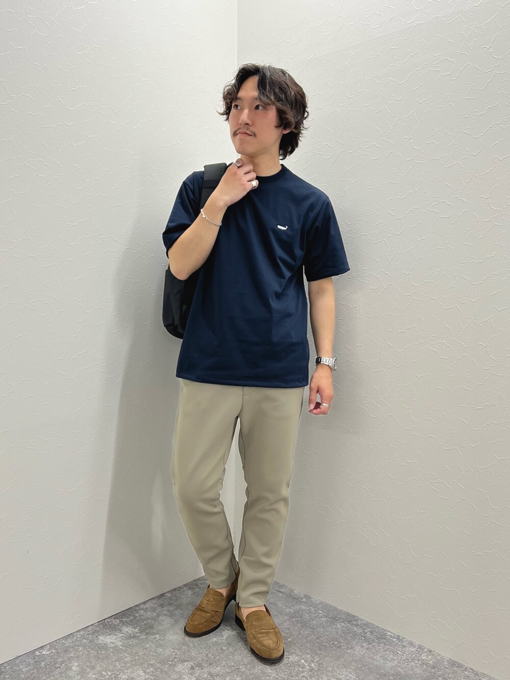 ブルー系のTシャツ/カットソー、ブラック系のバックパック/リュック、グリーン系のその他パンツを着用したメンズの春コーディネートの2枚目の写真