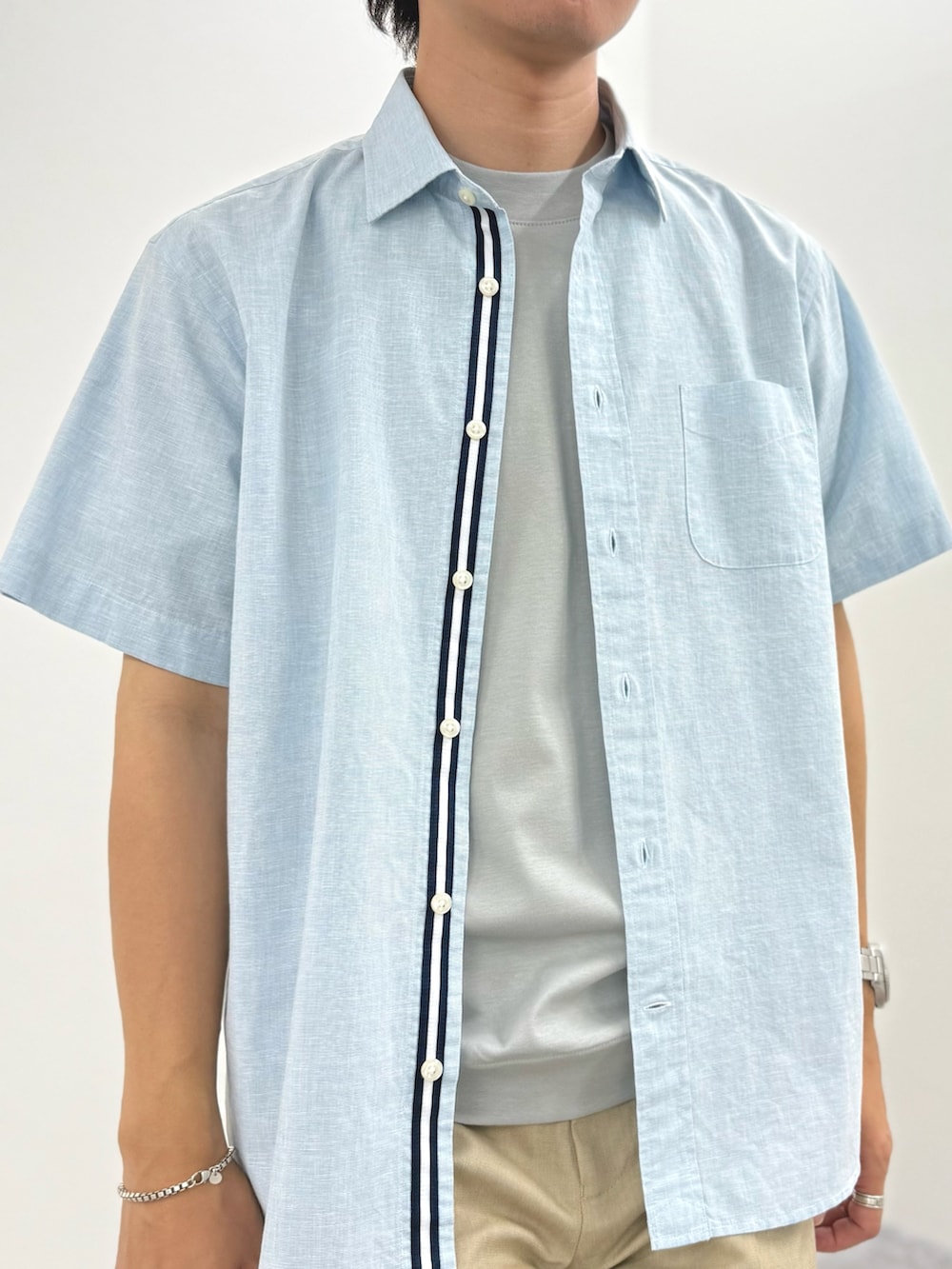 グリーン系のシャツ/ブラウス、グレー系のTシャツ/カットソー、ベージュ系のチノパンツを着用したメンズの夏コーディネートの6枚目の写真