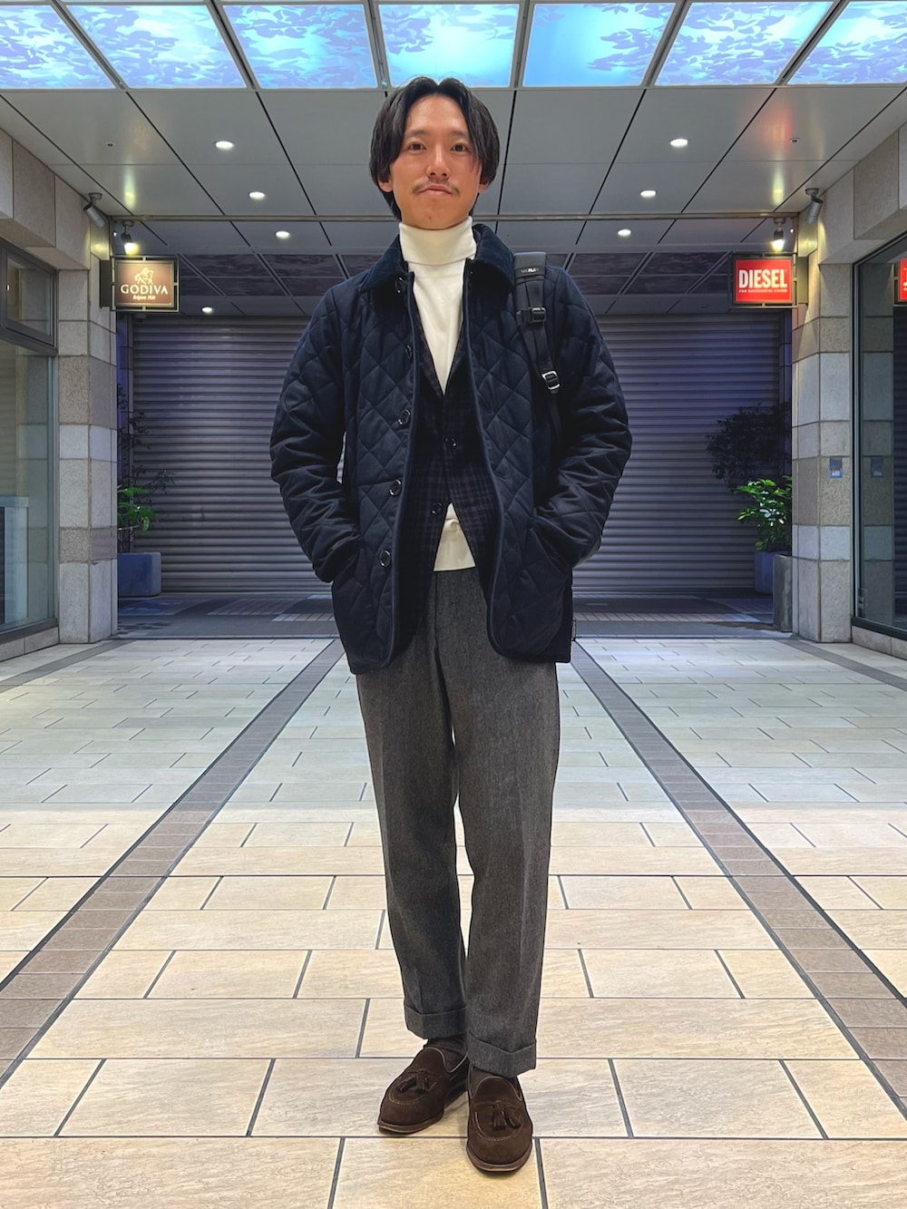 ブルー系のテーラードジャケット、ホワイト系のニット/セーター、ブラウン系のローファーを着用したメンズの冬コーディネートの3枚目の写真