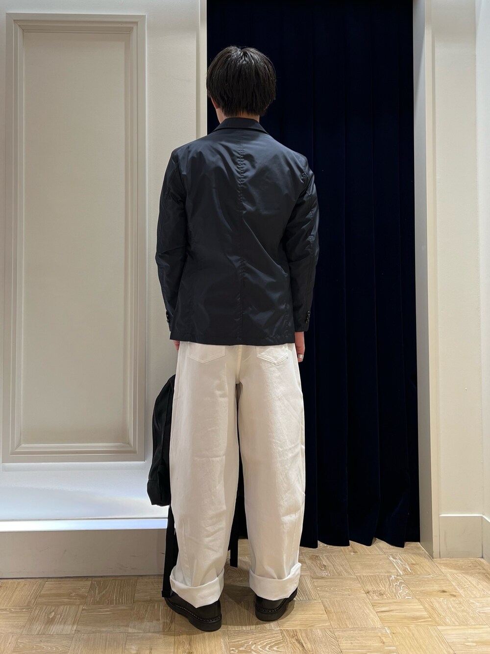 グレー系のスウェット、ブルー系のテーラードジャケット、ホワイト系のデニムパンツを着用したメンズの冬コーディネートの4枚目の写真