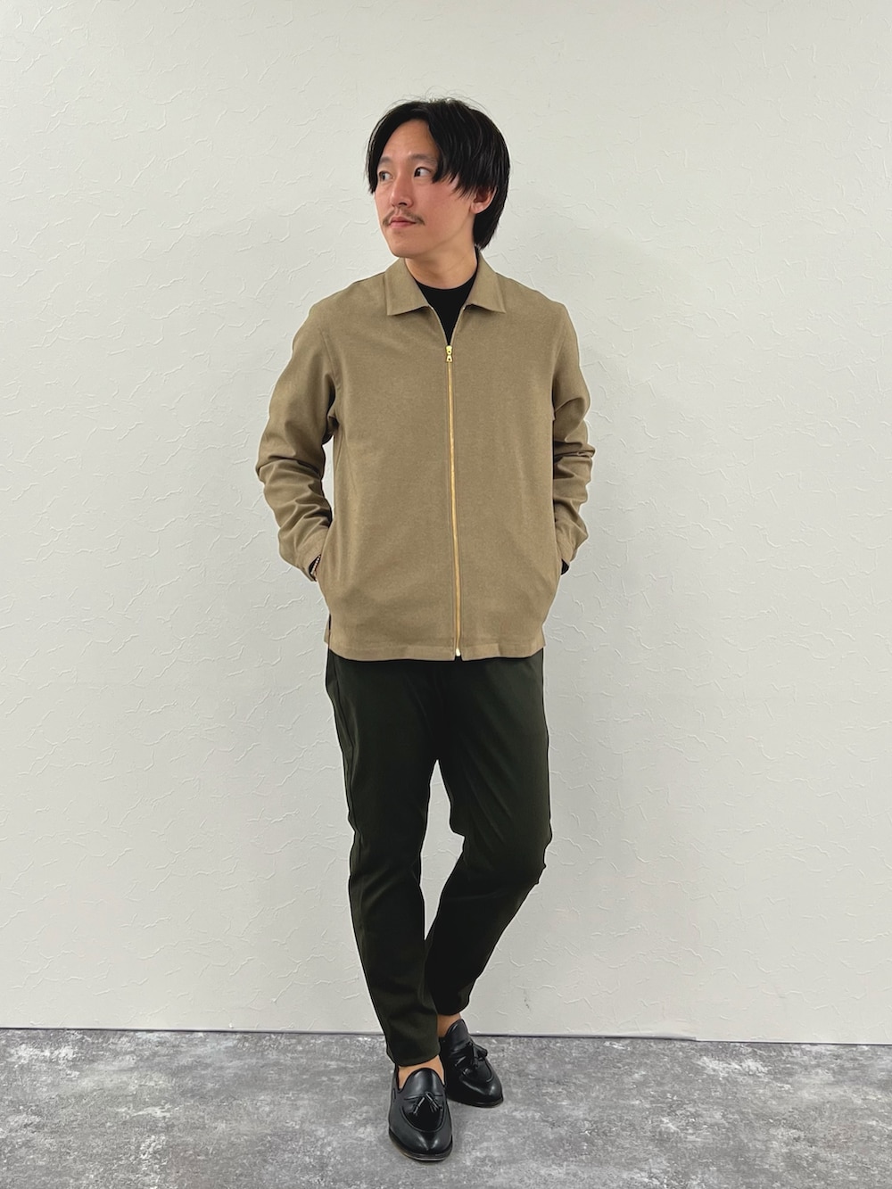 ベージュ系のブルゾン、ブラック系のTシャツ/カットソー、グリーン系のその他パンツを着用したメンズの秋コーディネートの3枚目の写真