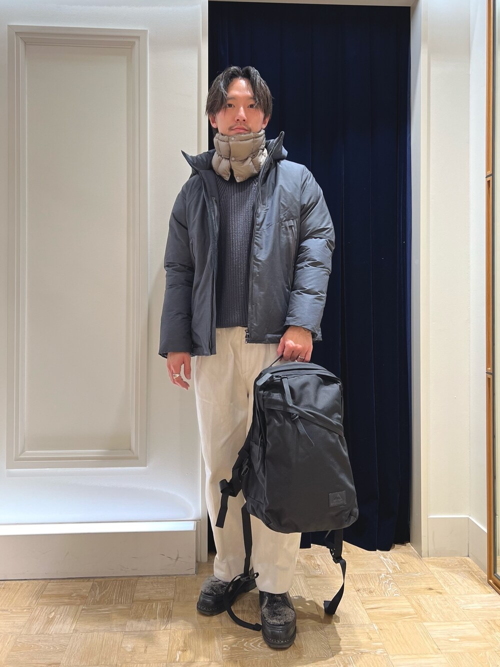 ブラック系のバックパック/リュック、グレー系のブルゾン、グリーン系のネックウォーマー/スヌードを着用したメンズの冬コーディネートの3枚目の写真