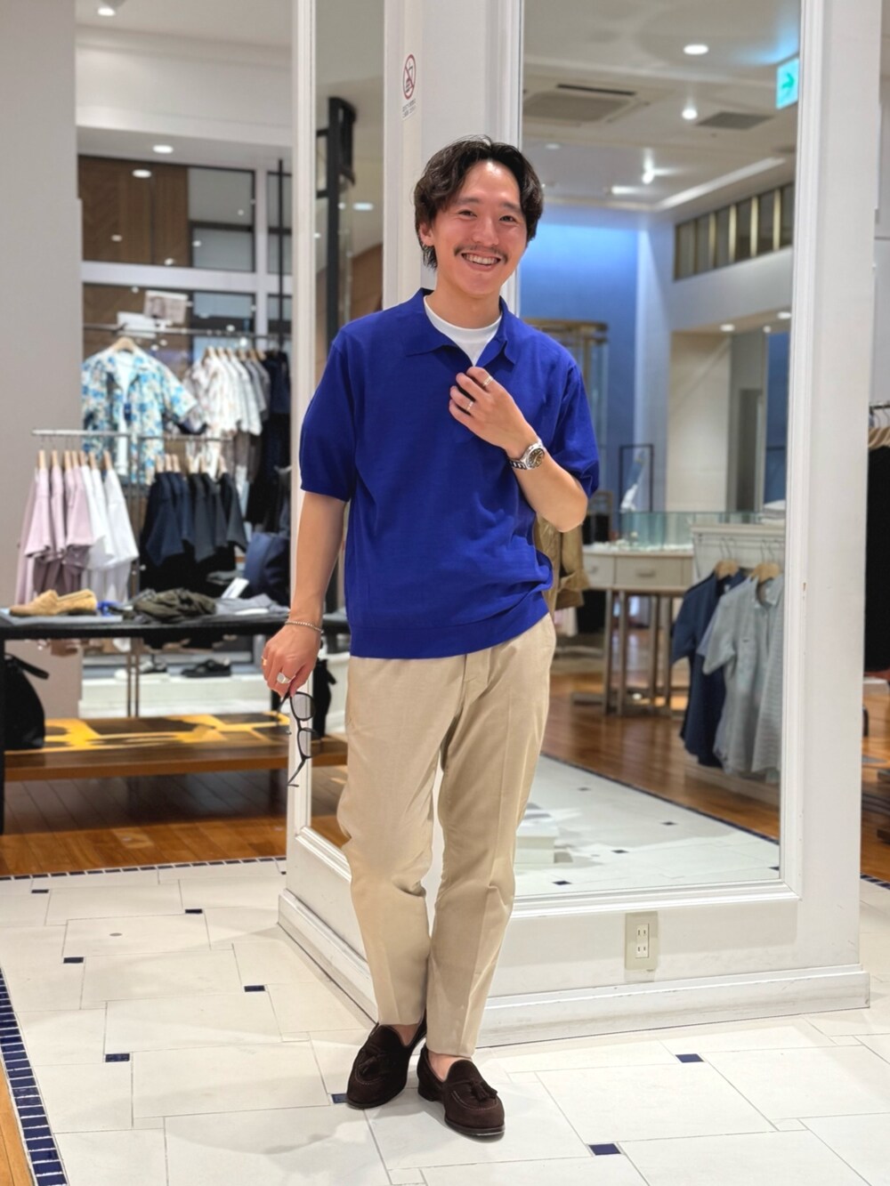 ブルー系のポロシャツ、ベージュ系のその他パンツ、ブラウン系のローファーを着用したメンズの春コーディネートの2枚目の写真