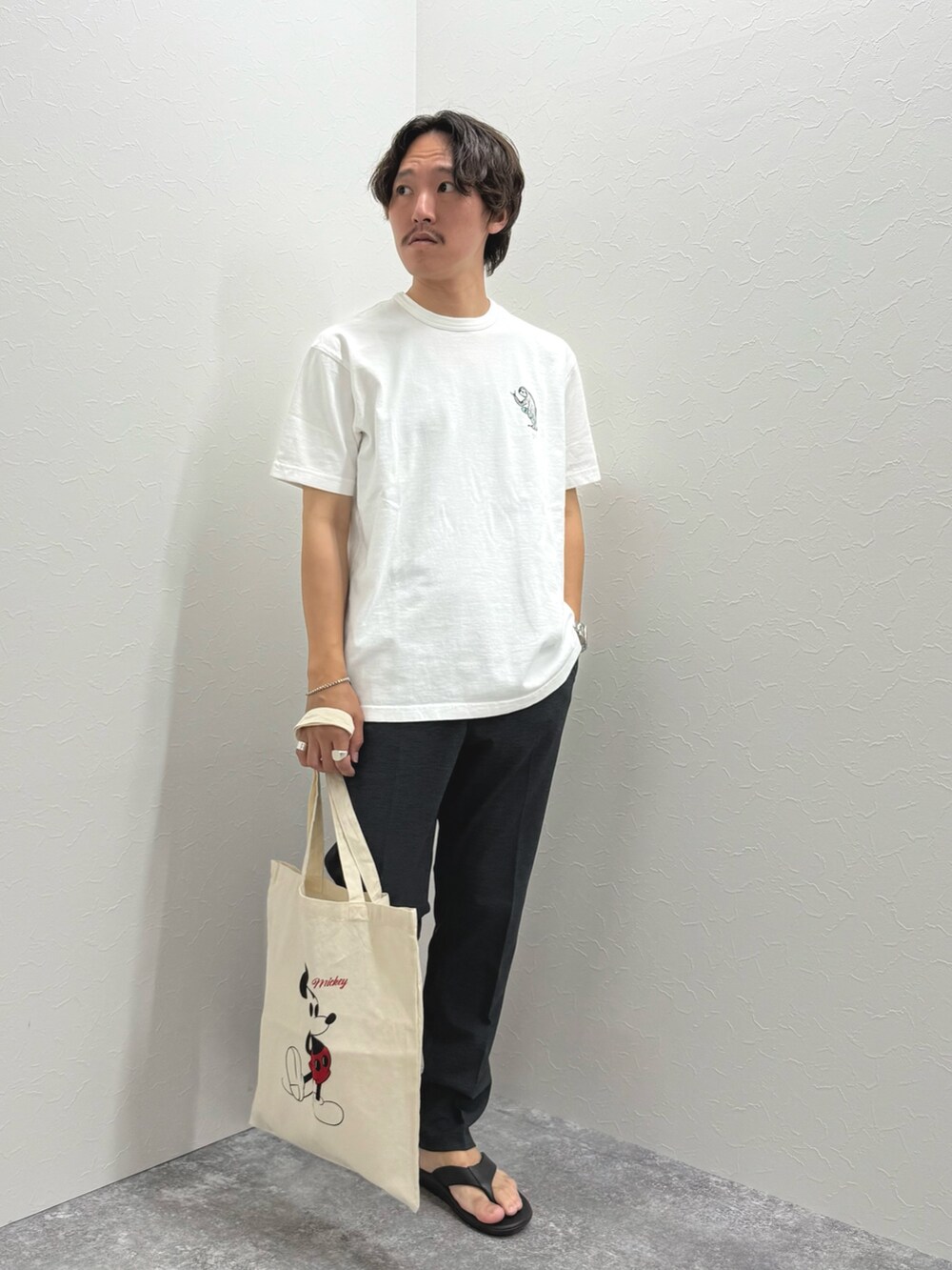 ホワイト系のTシャツ/カットソー、ホワイト系のトートバッグ、グレー系のその他パンツを着用したメンズの夏コーディネートの3枚目の写真