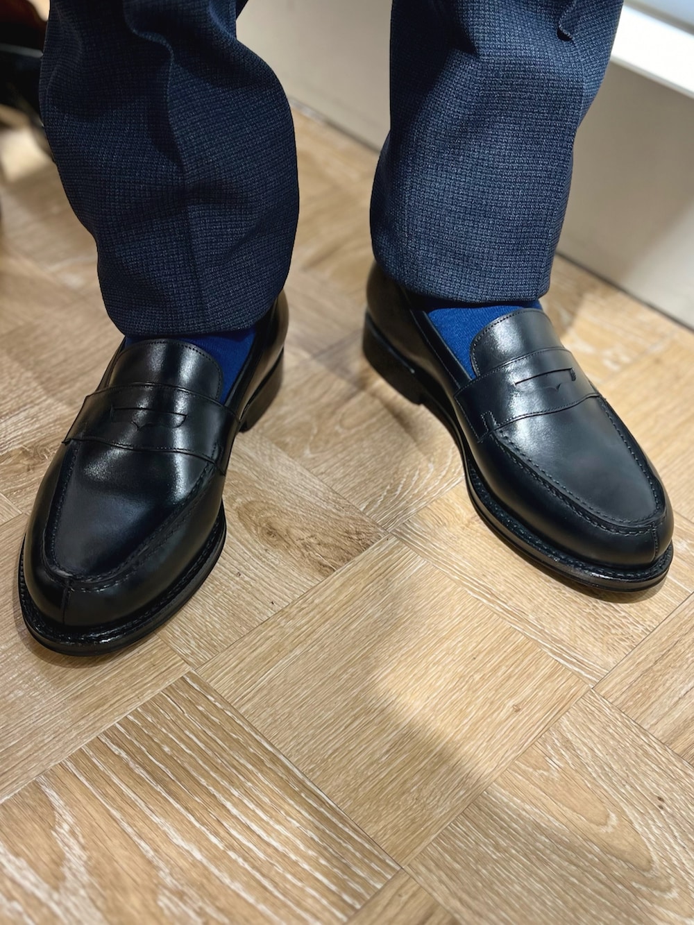 ブラック系のローファー、ブルー系のベスト、ブルー系のネクタイを着用したメンズの秋コーディネートの5枚目の写真