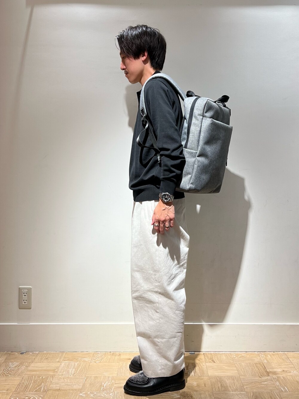 ブラック系のシューズ、ブラック系のニット/セーター、グレー系のバックパック/リュックを着用したメンズの秋コーディネートの3枚目の写真
