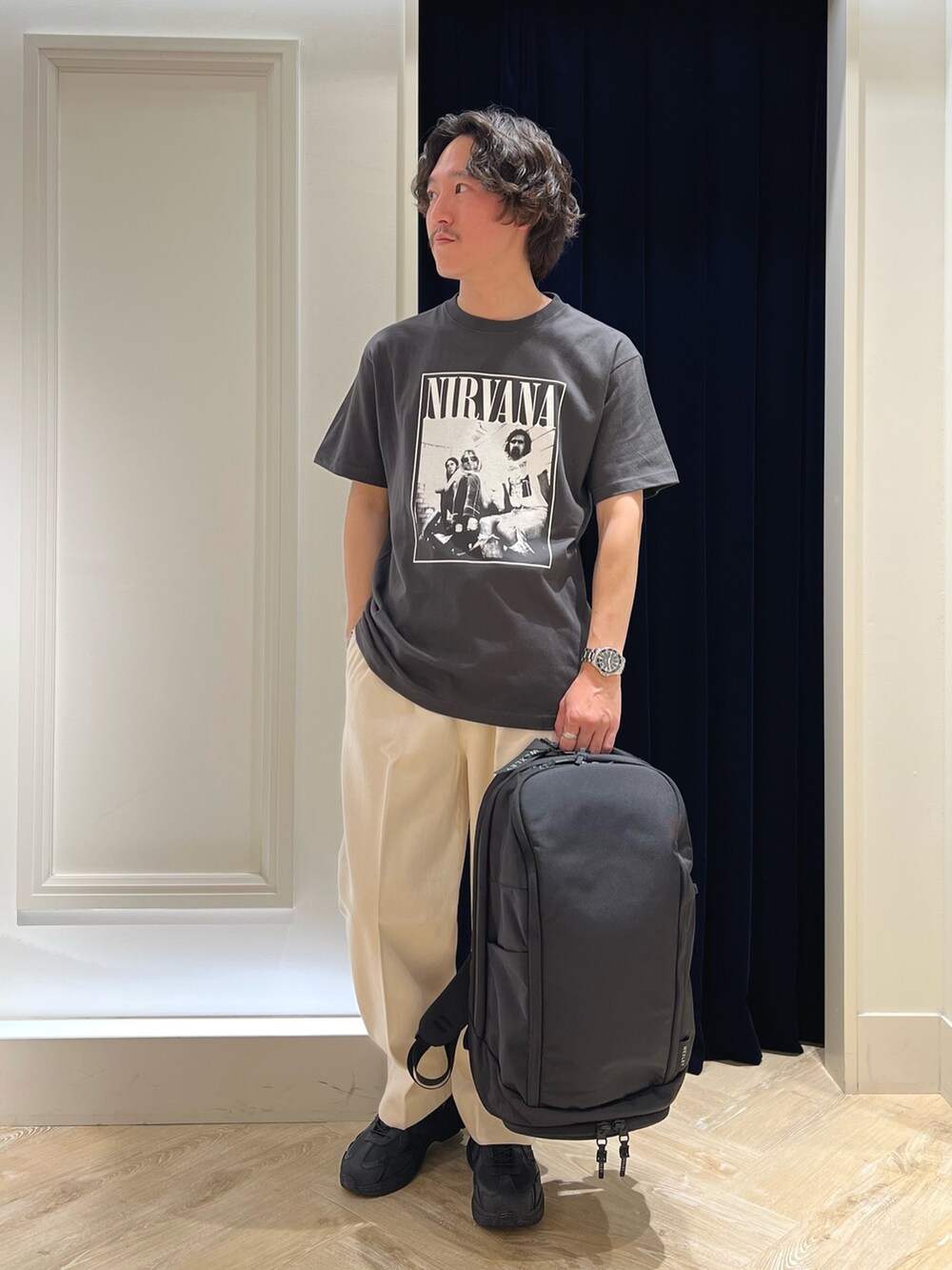 ブラック系のTシャツ/カットソー、ブラック系のバックパック/リュック、ブラック系のスニーカーを着用したメンズの春コーディネートの2枚目の写真