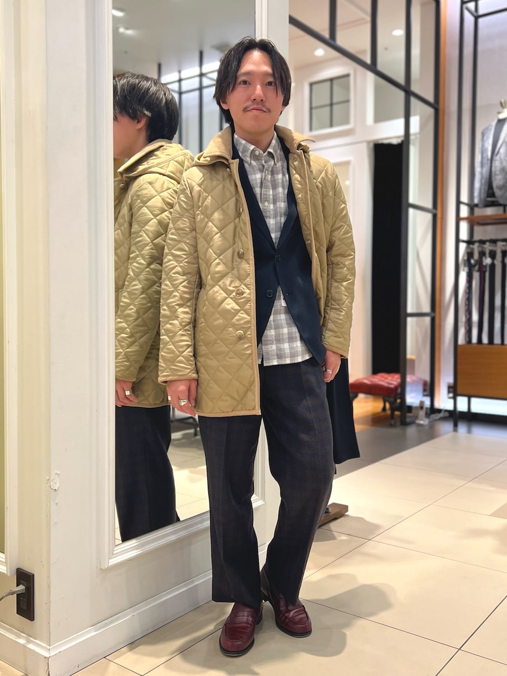 ベージュ系のブルゾン、ブルー系のテーラードジャケット、ブラウン系のローファーを着用したメンズの冬コーディネートの2枚目の写真