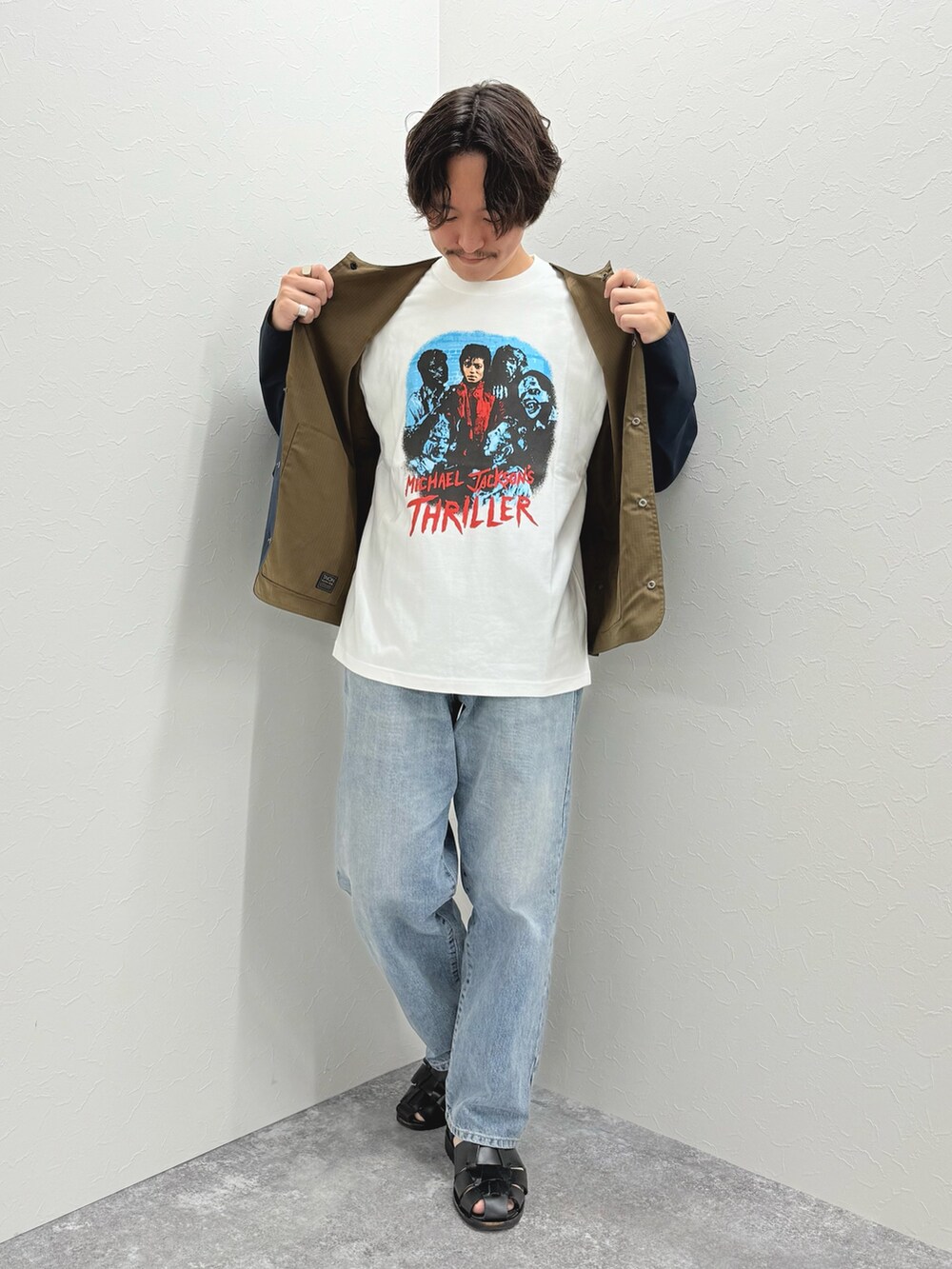 ブルー系のブルゾン、ホワイト系のTシャツ/カットソー、ブラック系のサンダルを着用したメンズの春コーディネートの3枚目の写真