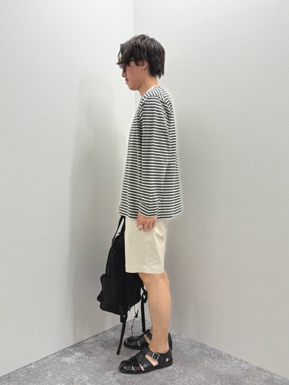 グレー系のTシャツ/カットソー、ホワイト系のその他パンツ、ブラック系のバックパック/リュックを着用したメンズの春コーディネートの6枚目の写真