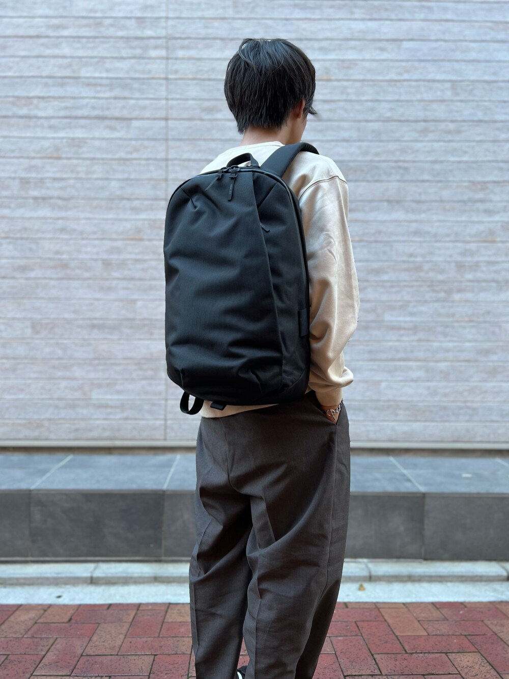 ホワイト系のスウェット、ブラック系のバックパック/リュックを着用したメンズの秋コーディネートの3枚目の写真