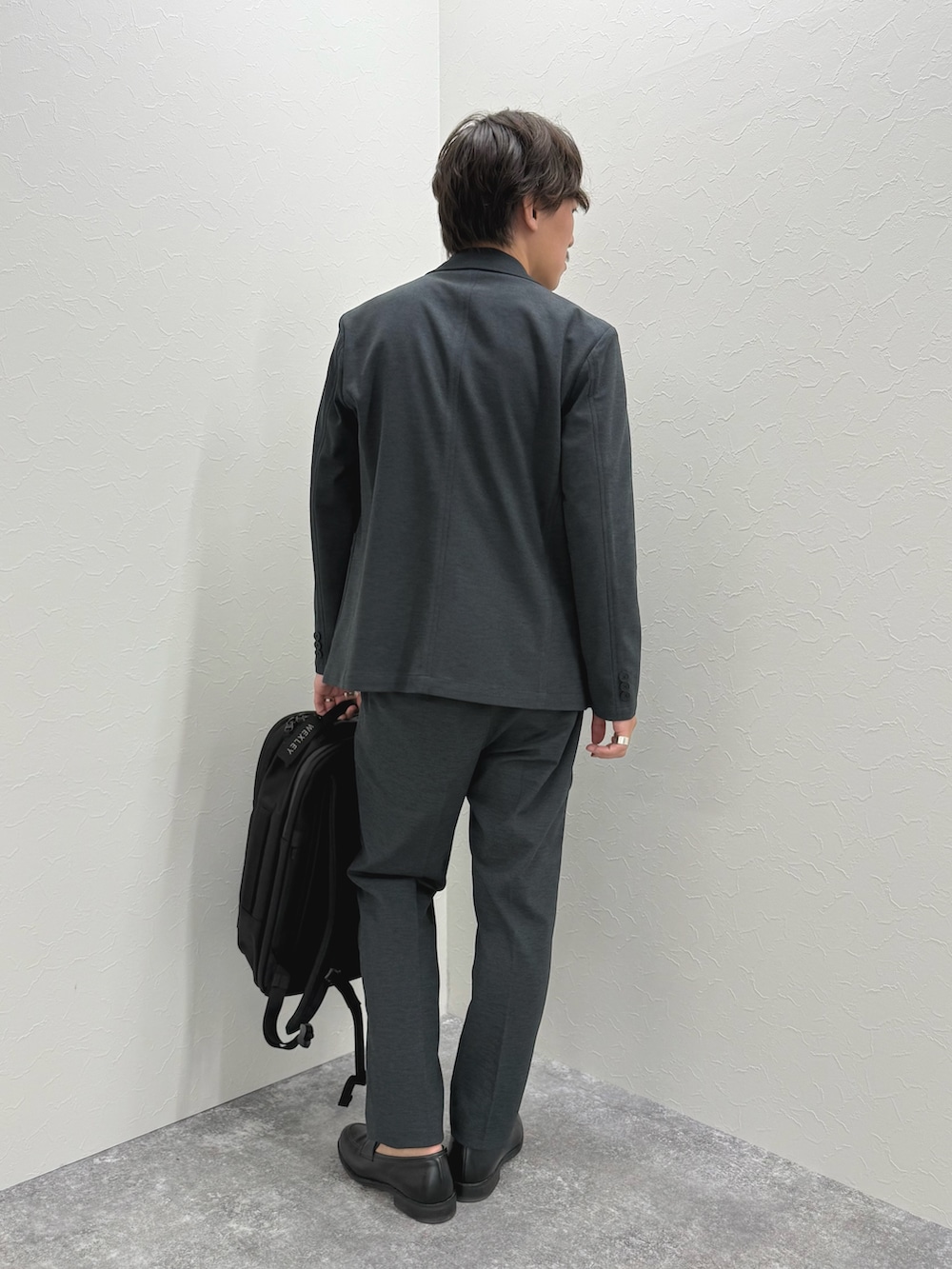 ブラック系のバックパック/リュック、ブラック系のローファー、ブルー系のTシャツ/カットソーを着用したメンズの夏コーディネートの6枚目の写真