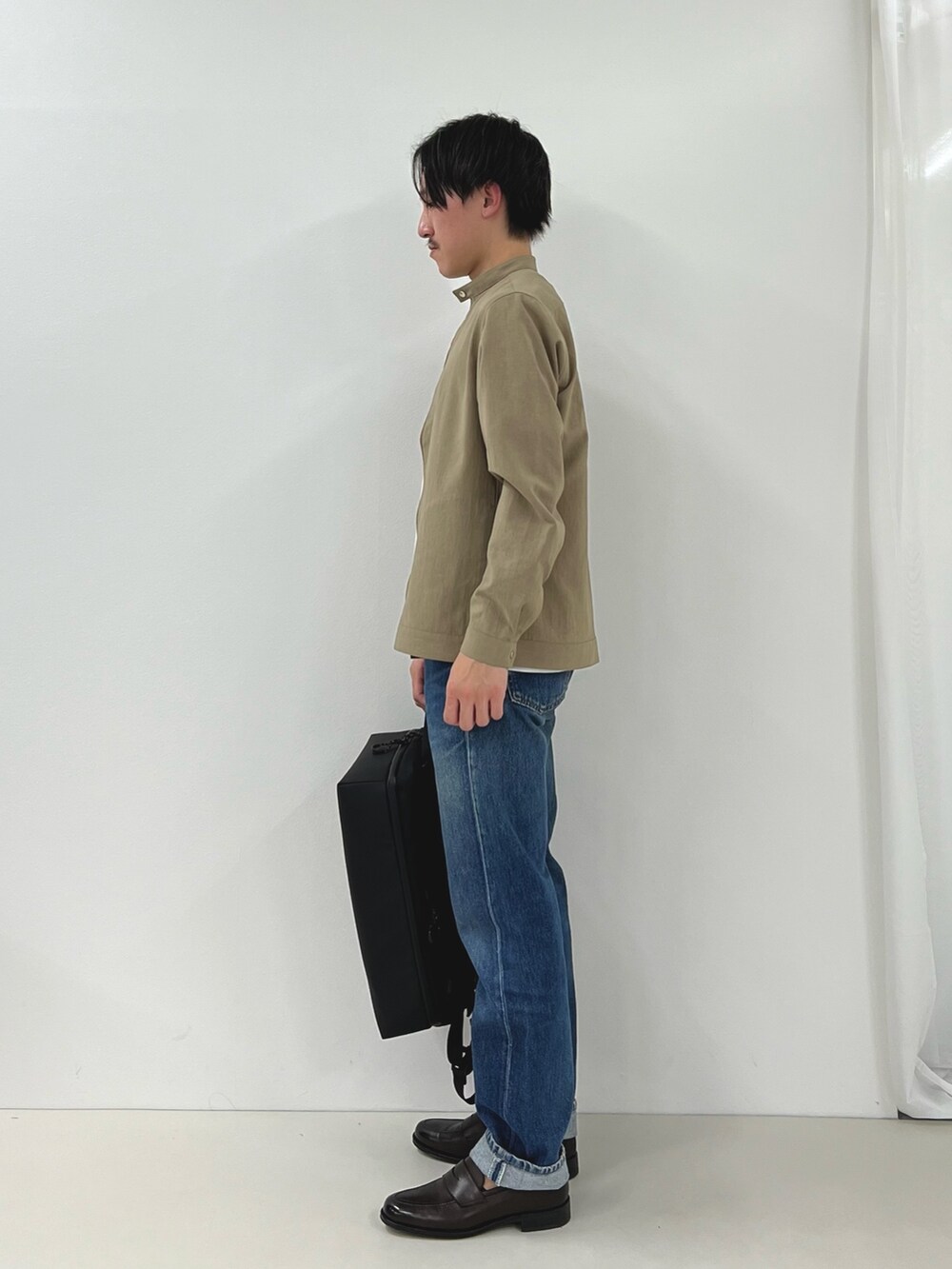 ホワイト系のTシャツ/カットソー、ベージュ系のブルゾン、ブラック系のバックパック/リュックを着用したメンズの春コーディネートの3枚目の写真