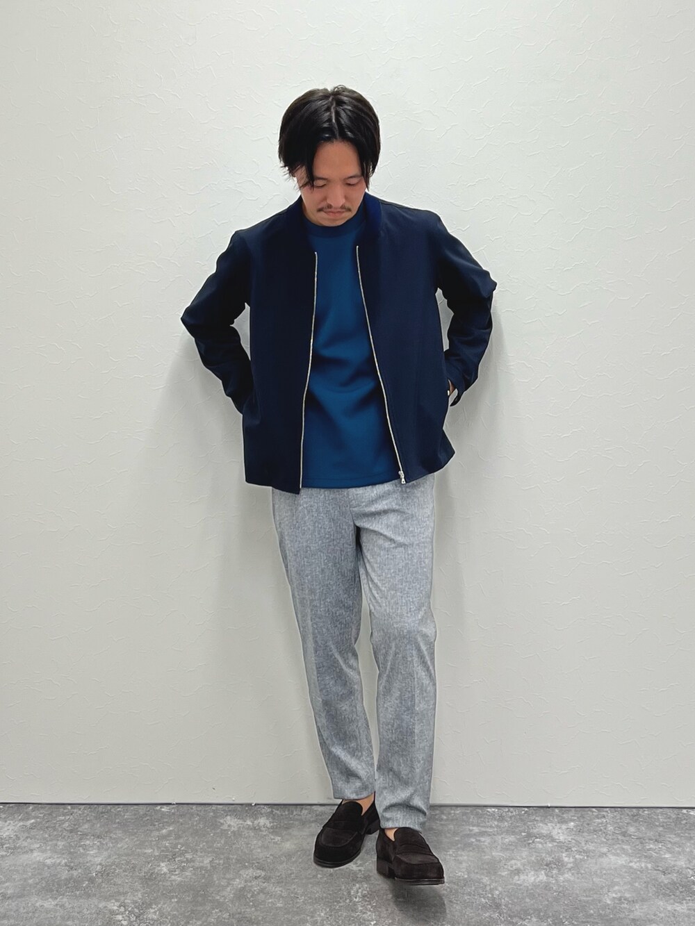ブルー系のブルゾン、ブルー系のTシャツ/カットソー、グレー系のその他パンツを着用したメンズの秋コーディネートの4枚目の写真