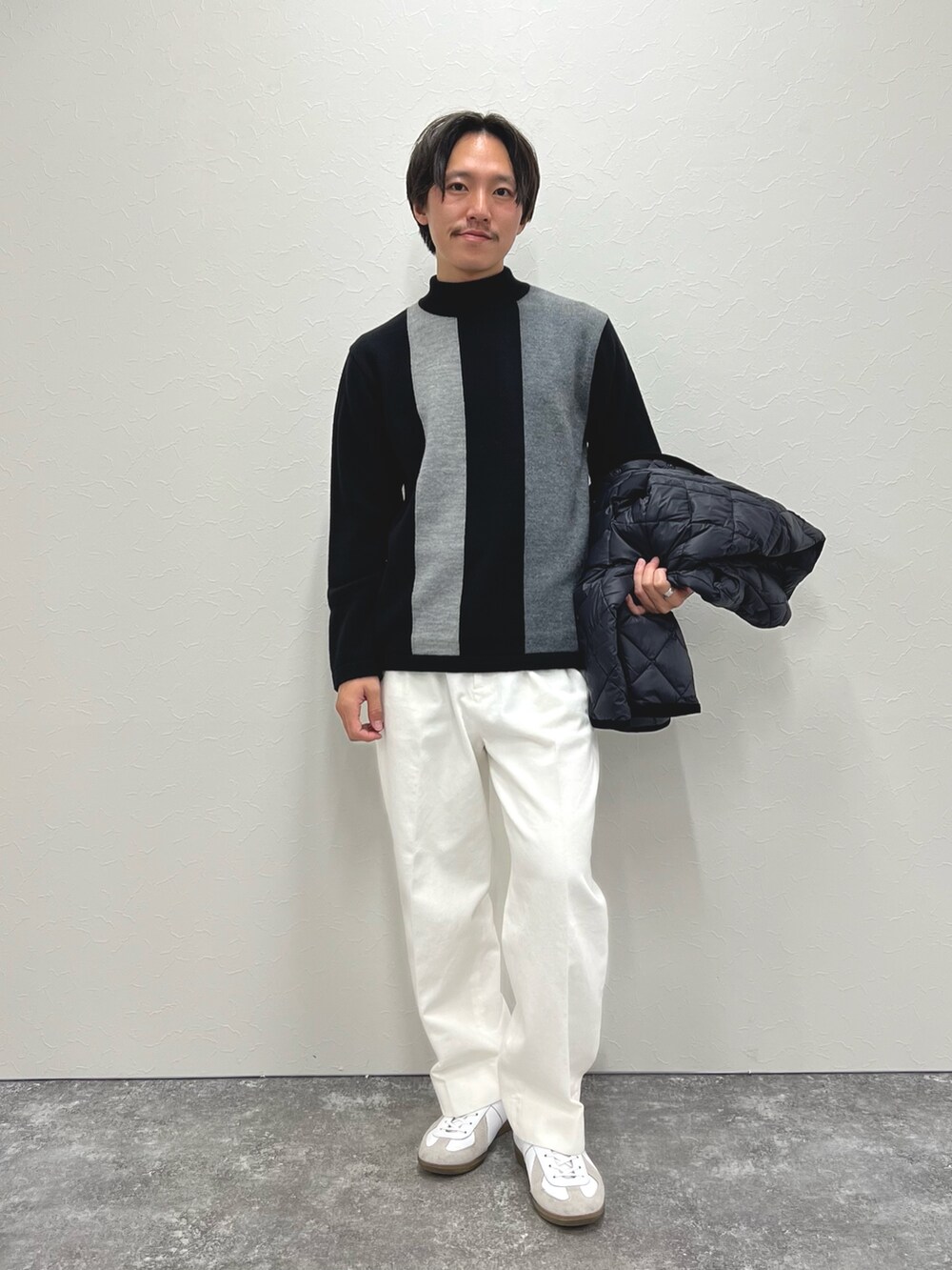 ブラック系のニット/セーター、ホワイト系のデニムパンツ、ブラック系のブルゾンを着用したメンズの冬コーディネートの7枚目の写真