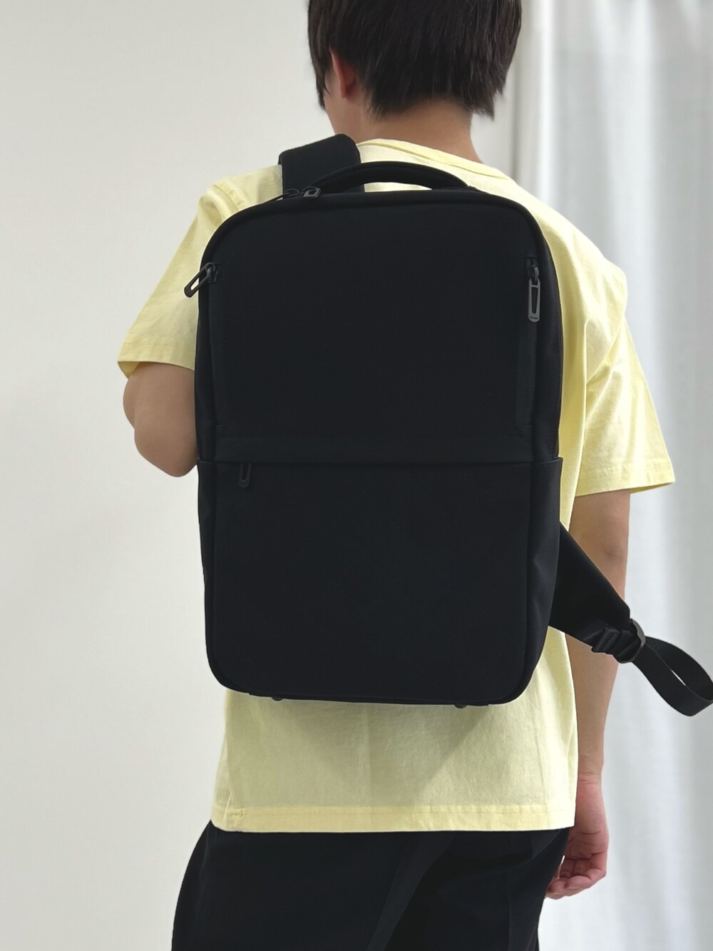 イエロー系のTシャツ/カットソー、ブルー系のその他パンツ、ブラック系のバックパック/リュックを着用したメンズの春コーディネートの5枚目の写真