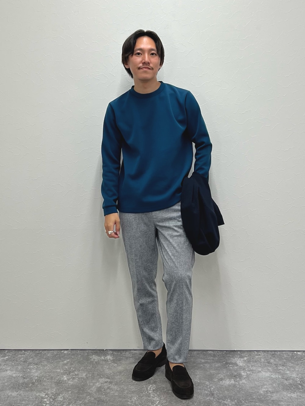 ブルー系のブルゾン、ブルー系のTシャツ/カットソー、グレー系のその他パンツを着用したメンズの秋コーディネートの3枚目の写真