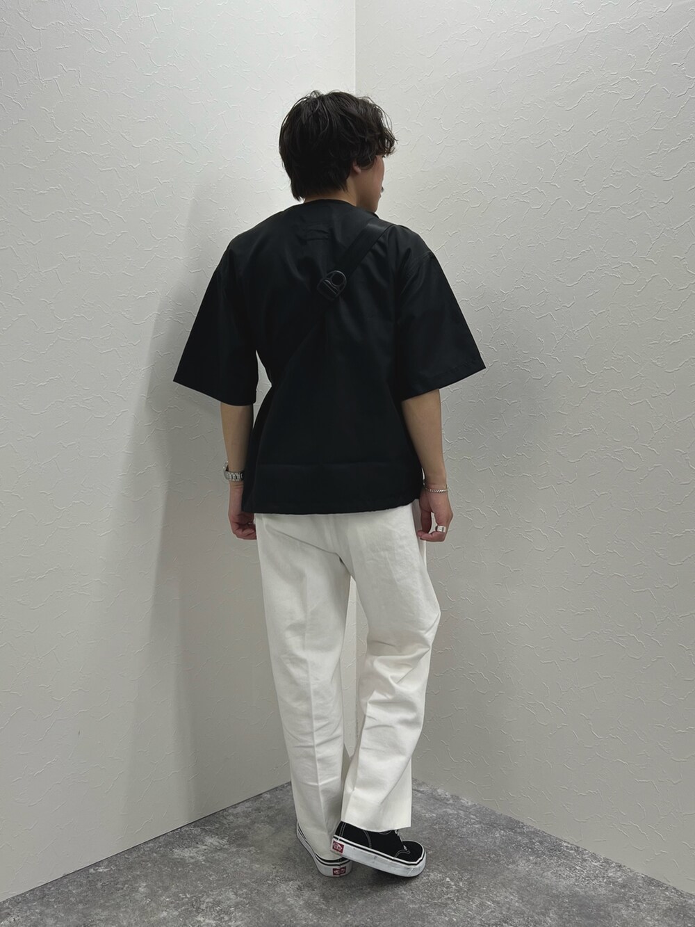 ブラック系のTシャツ/カットソー、ブルー系のショルダーバッグ、ホワイト系のデニムパンツを着用したメンズの春コーディネートの6枚目の写真