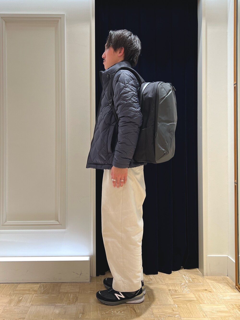 ブルー系のダウンジャケット/コート、イエロー系のニット/セーター、ブラック系のバックパック/リュックを着用したメンズの冬コーディネートの4枚目の写真