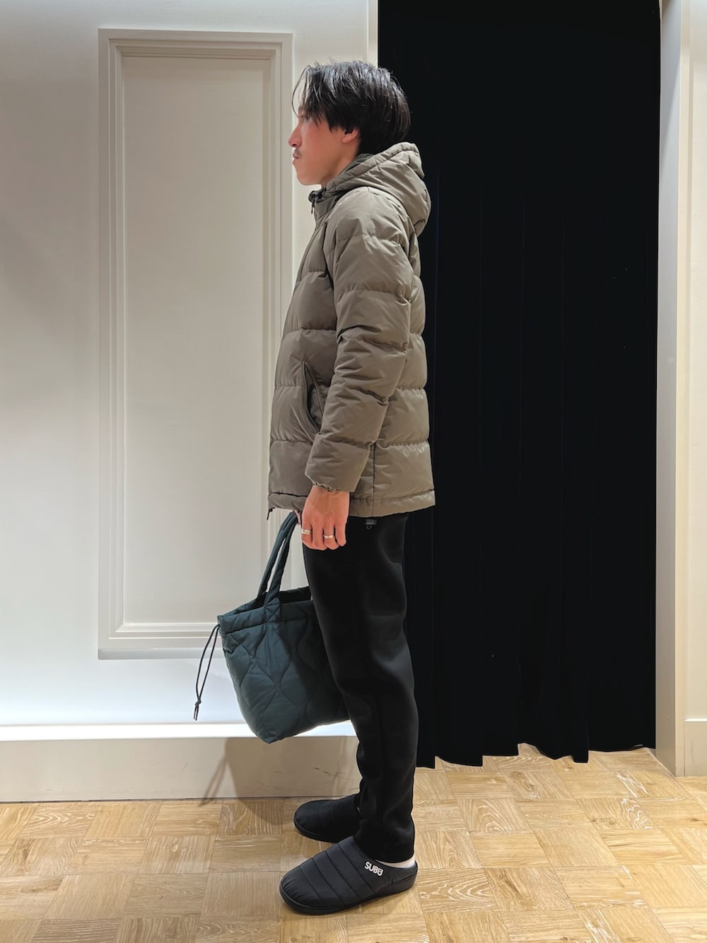 グリーン系のダウンジャケット/コート、ブルー系のシャツ/ブラウス、ブラック系のその他パンツを着用したメンズの秋コーディネートの4枚目の写真