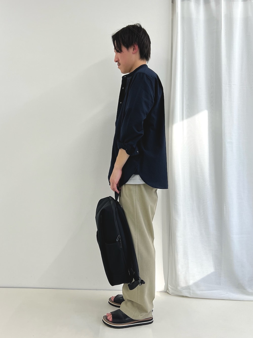 ブラック系のバックパック/リュック、ブラック系のサンダル、ブルー系のシャツ/ブラウスを着用したメンズの春コーディネートの4枚目の写真