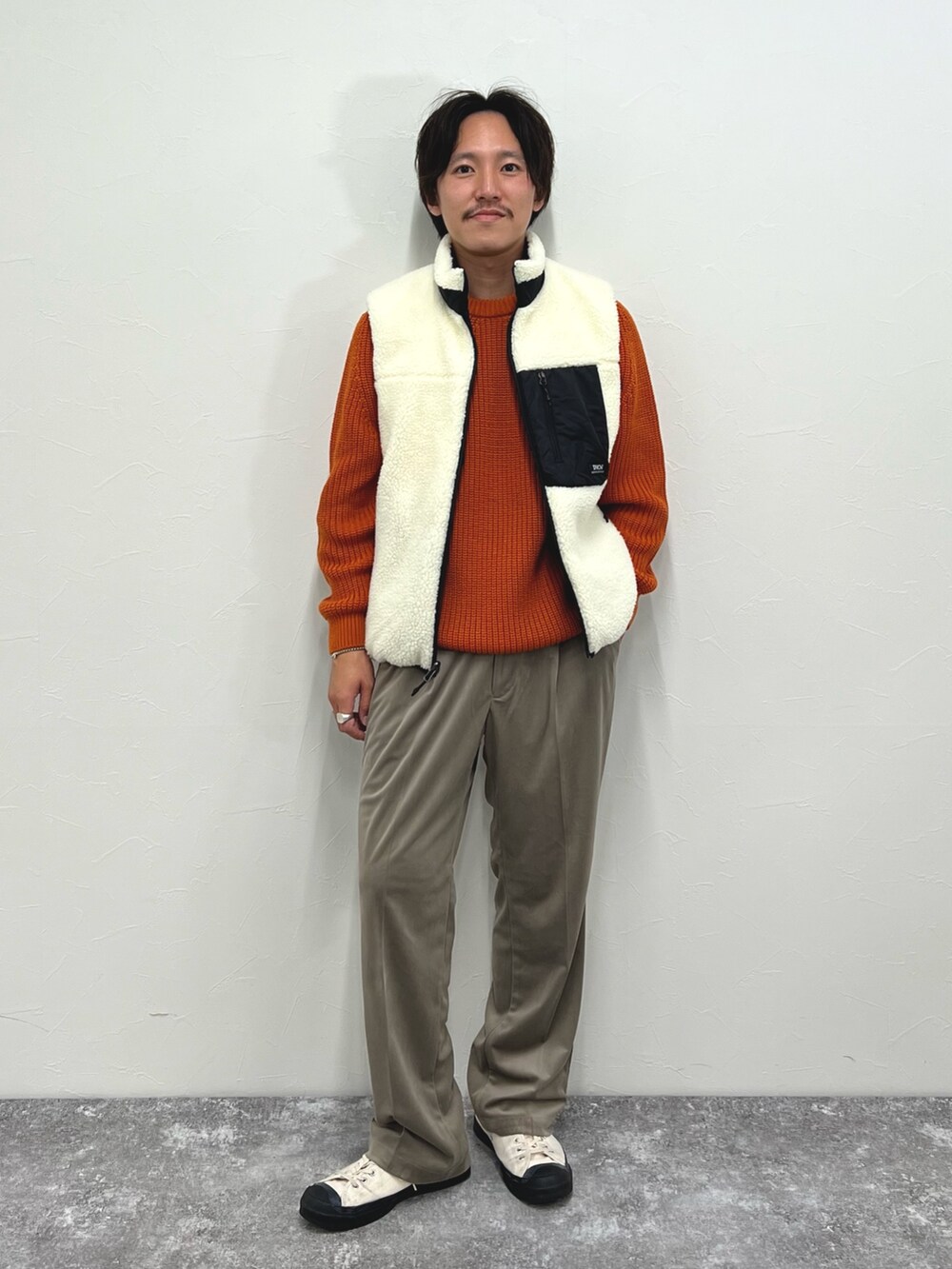 ホワイト系のダウンベスト、ベージュ系のその他パンツを着用したメンズの秋コーディネートの3枚目の写真