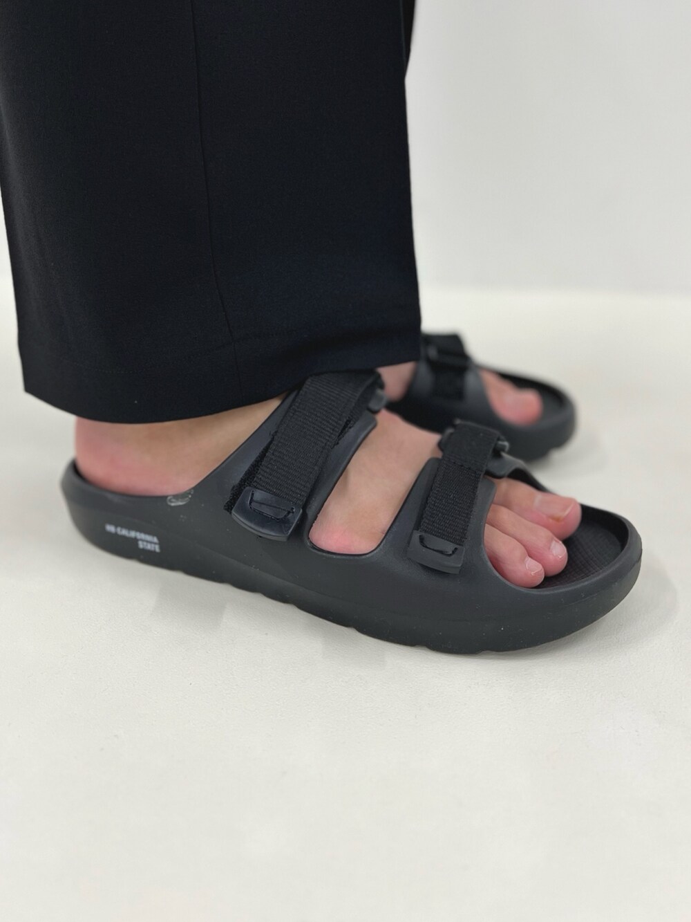 ブルー系のTシャツ/カットソー、ブラック系のその他パンツ、ブラック系のサンダルを着用したメンズの春コーディネートの9枚目の写真