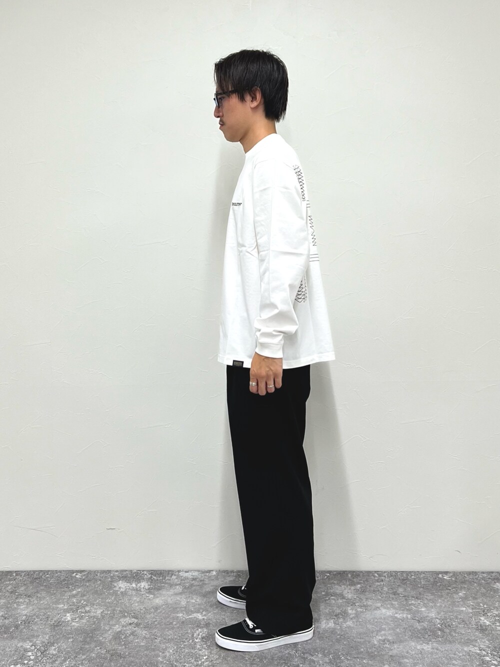 ホワイト系のTシャツ/カットソー、ブラック系のスニーカーを着用したメンズの秋コーディネートの4枚目の写真