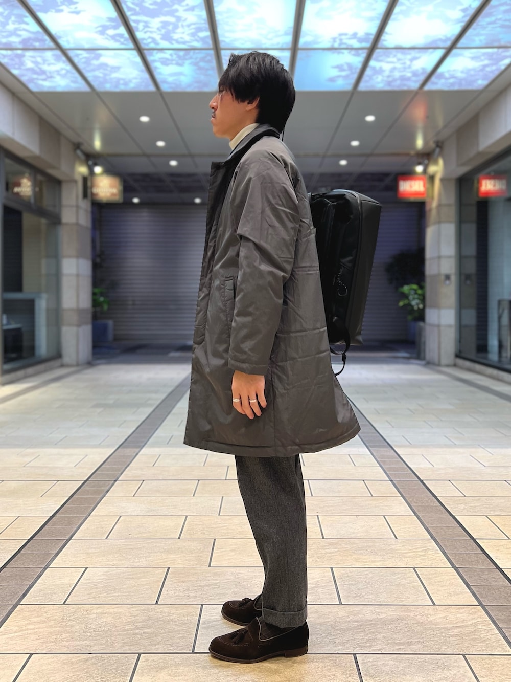 グレー系のダウンジャケット/コート、ブルー系のシャツ/ブラウス、ホワイト系のニット/セーターを着用したメンズの冬コーディネートの4枚目の写真