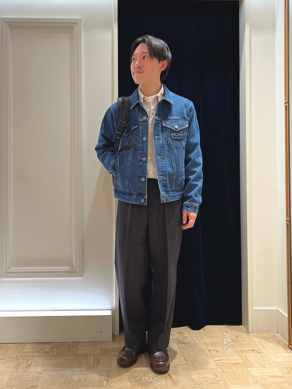 ブルー系のデニムジャケット、ベージュ系のシャツ/ブラウス、ブラック系のバックパック/リュックを着用したメンズの冬コーディネートの2枚目の写真