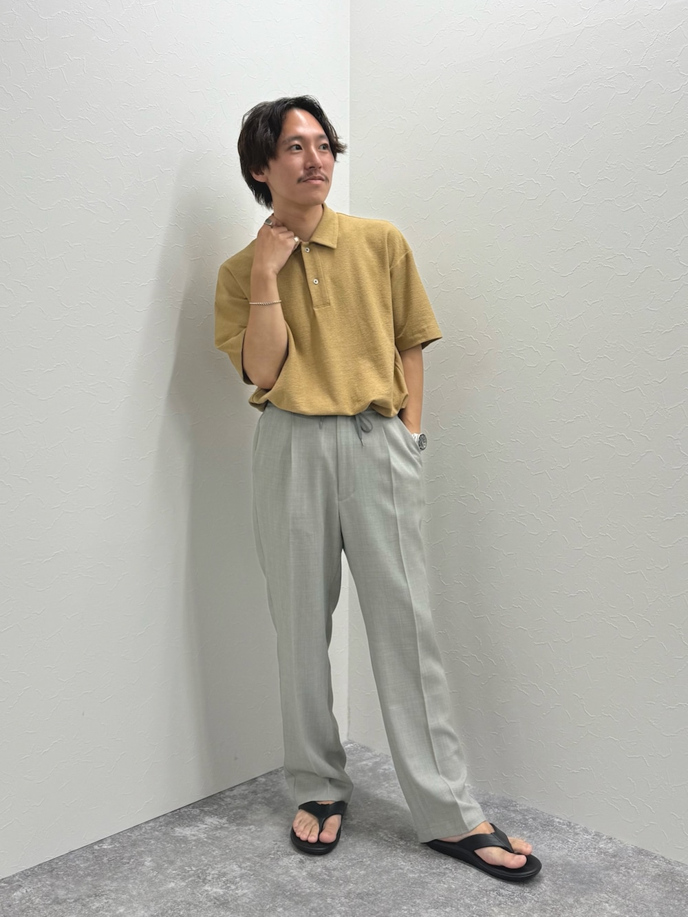 ベージュ系のポロシャツ、ブラック系のサンダルを着用したメンズの夏コーディネートの4枚目の写真