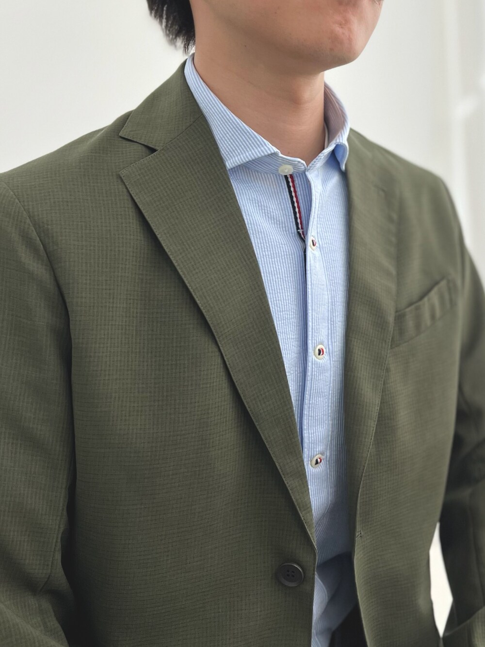 ブルー系のシャツ/ブラウス、グレー系のチノパンツ、グリーン系のテーラードジャケットを着用したメンズの夏コーディネートの7枚目の写真