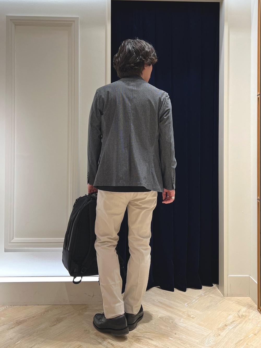 グレー系のテーラードジャケット、ブラック系のTシャツ/カットソー、ホワイト系のチノパンツを着用したメンズの春コーディネートの6枚目の写真